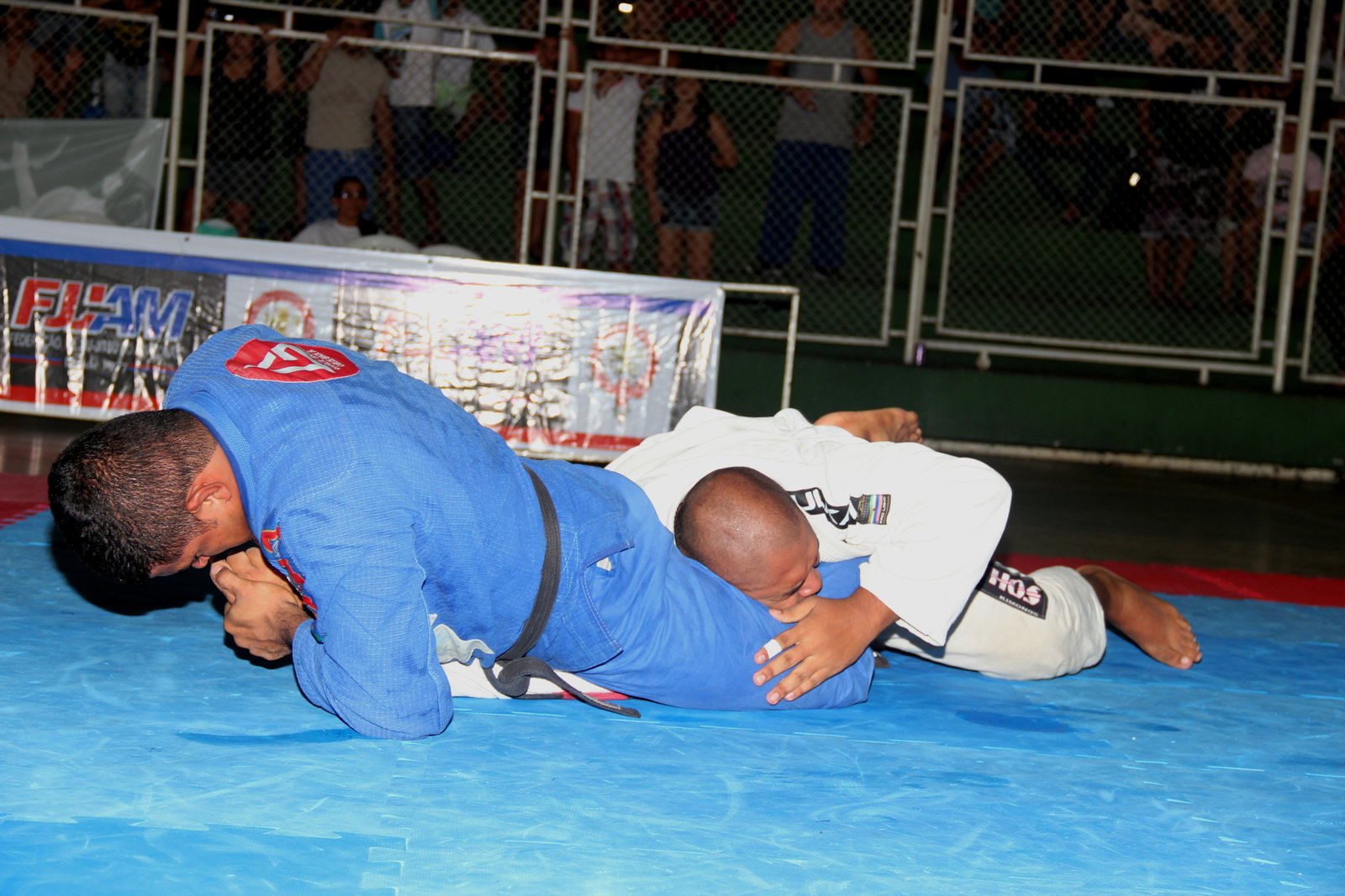 Thiago Reinaldo competing on the ground in a blue gi in Manaus