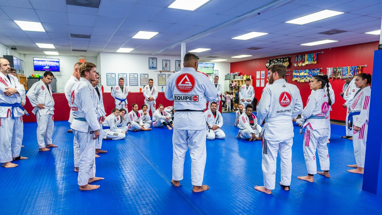 Professor Thiago Reinaldo leading a room of adult students at Gracie Barra Stafford